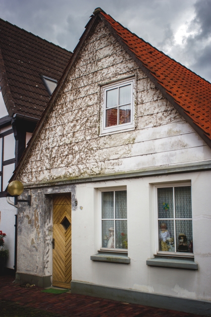 Casa en Nienburg con algunos muñecos en las ventanas como si de un escaparate se tratara.